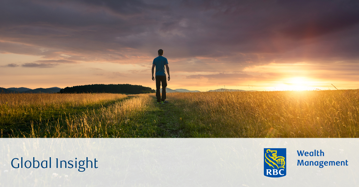 Man walking in field at sunset