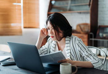 Asian woman reviewing computer