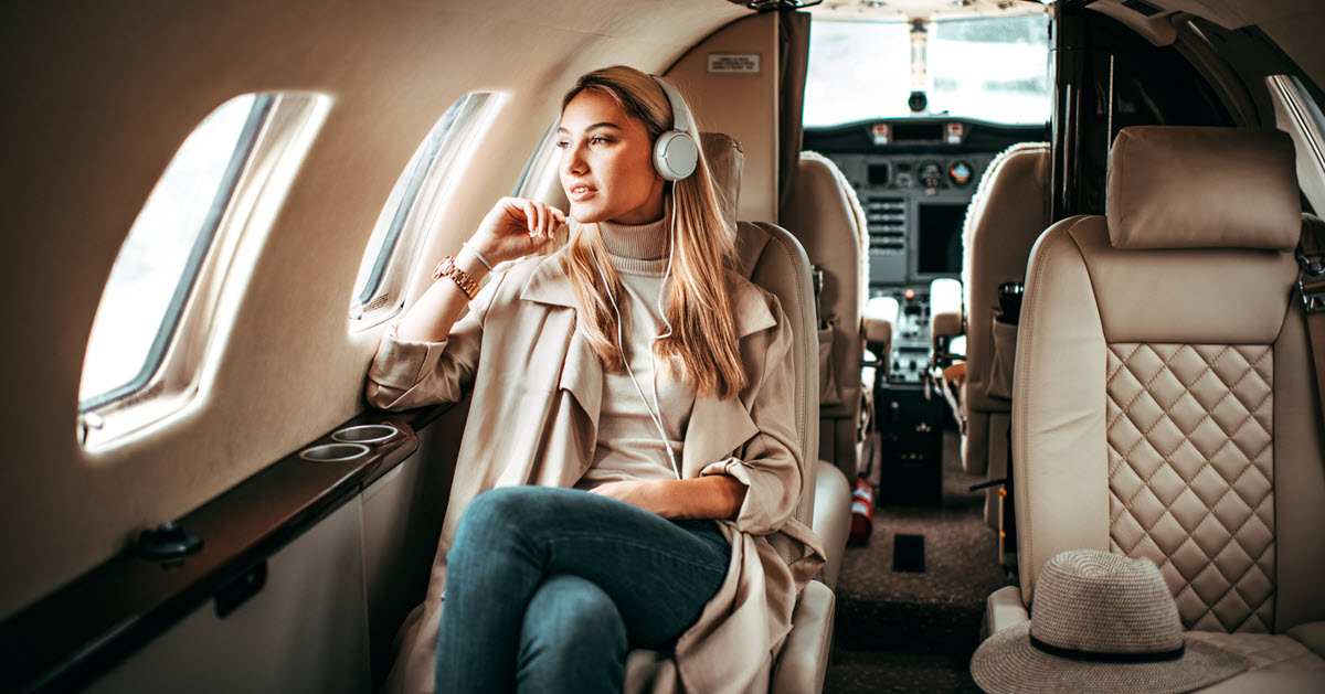 Young woman on luxury airplane looking out window