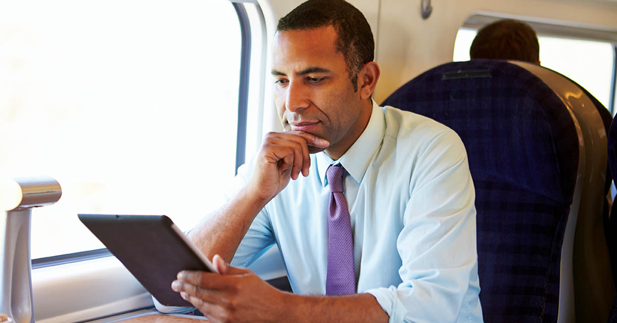 Man looking at tablet on plane
