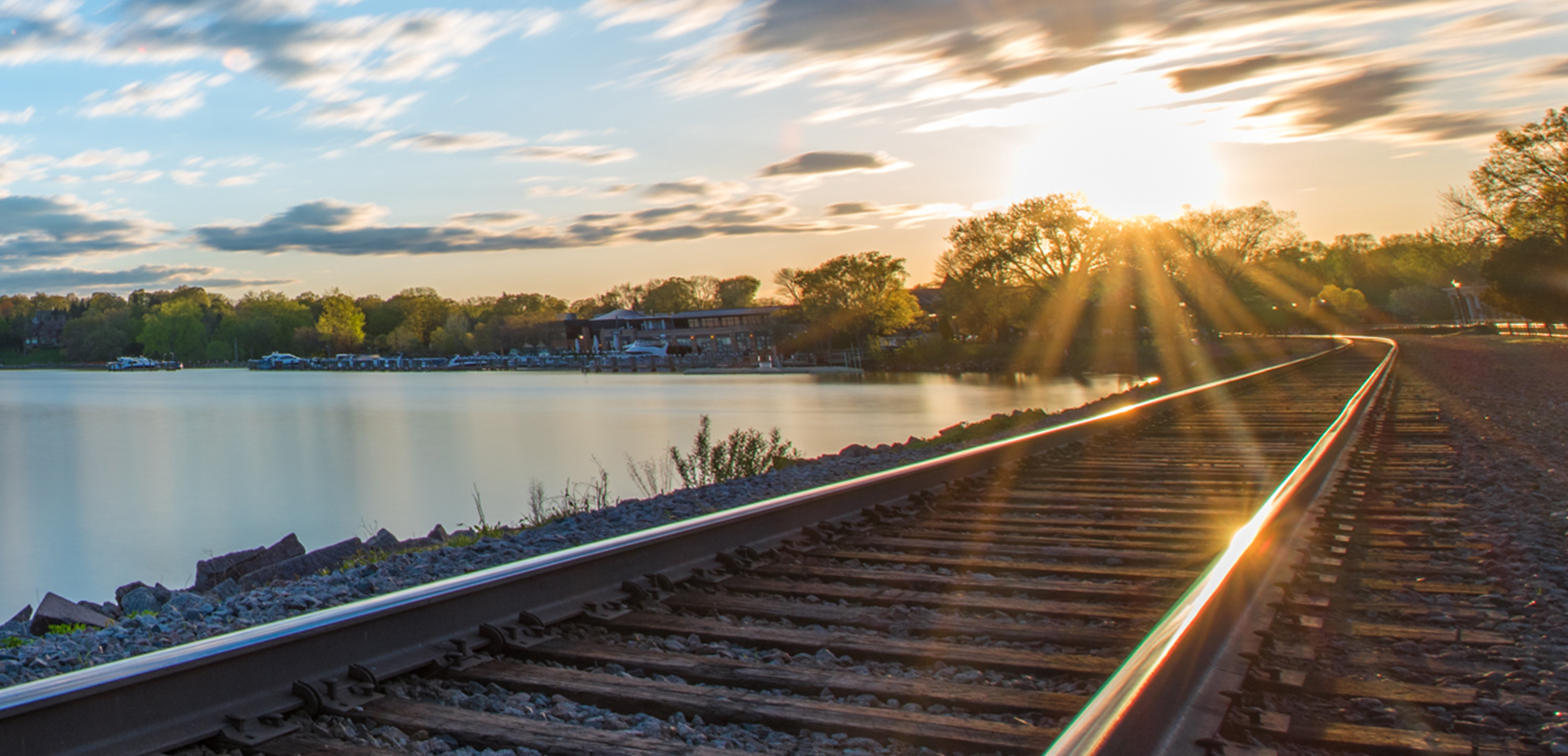 railroad tracks alongside lake