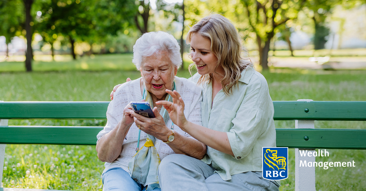 Younger woman helping older woman with her smart phone