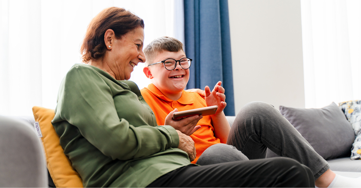 Boy with Down syndrome laughing with mother