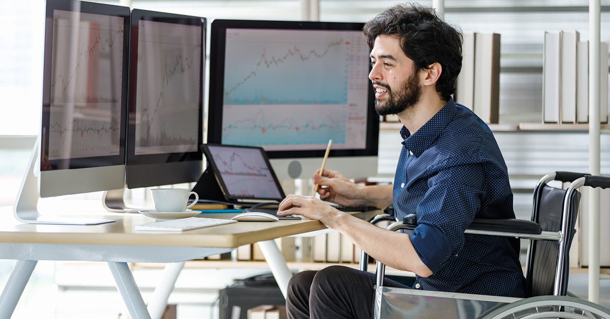 Man looking at investments on computer monitors