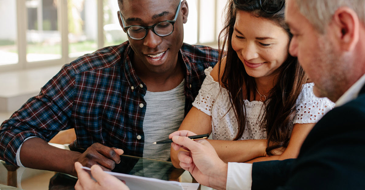 Couple talking with their tax advisor reviewing documents