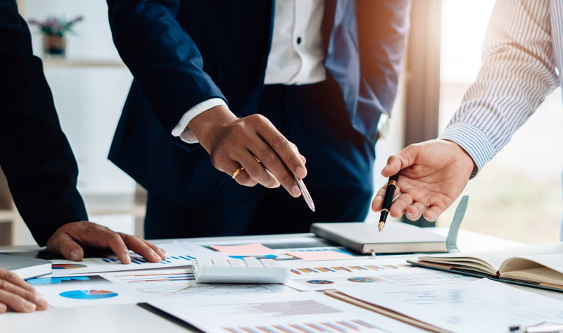 Business professionals engaged in a strategy discussion around a conference table.