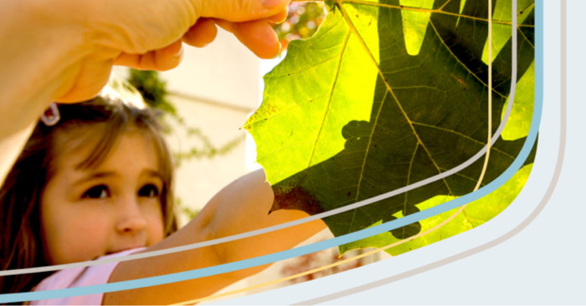 Parent showing daughter a large leaf