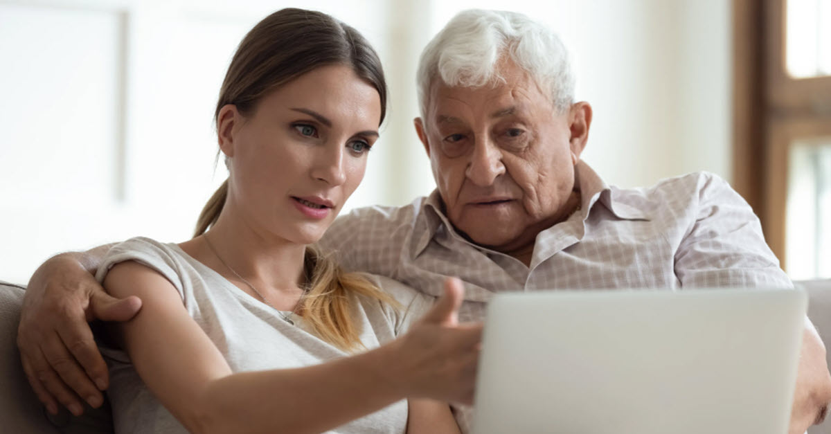 Daughter helping elderly father on the computer