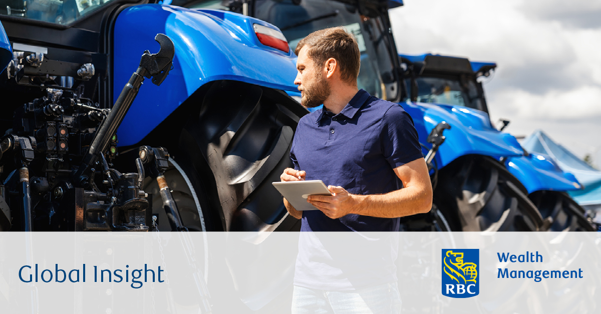 Man holding a tablet inspecting tractors