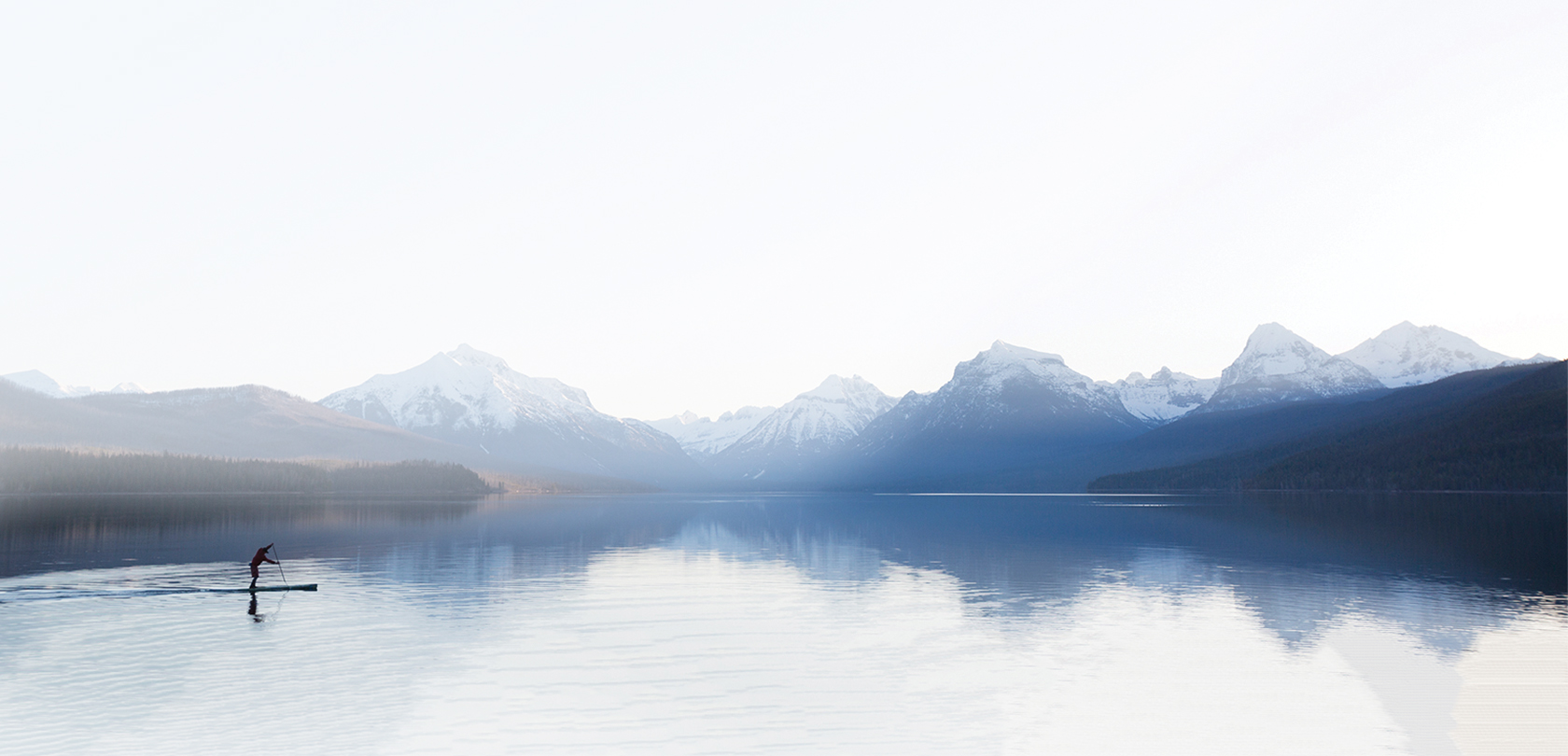 mountains and lake with paddleboarding