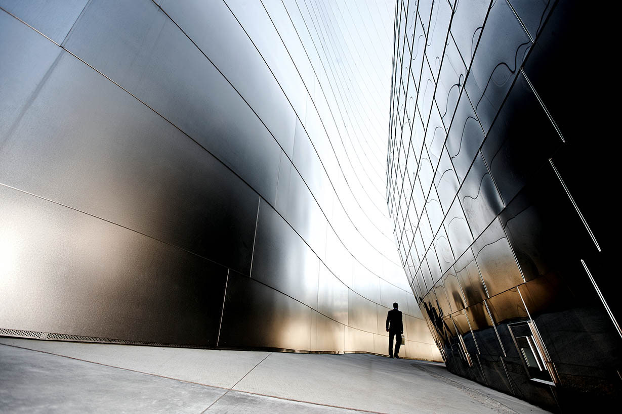 Man walking alongside a mirrored building