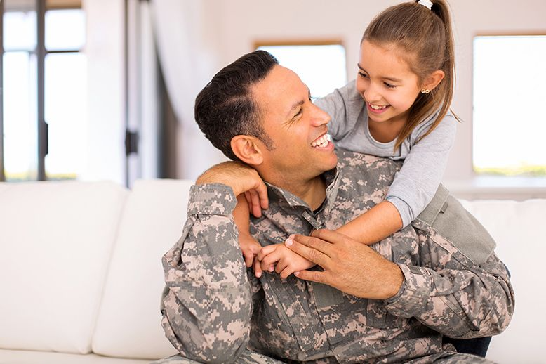 Girl hugging military father
