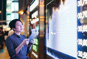 Woman looking at research on screen on wall.