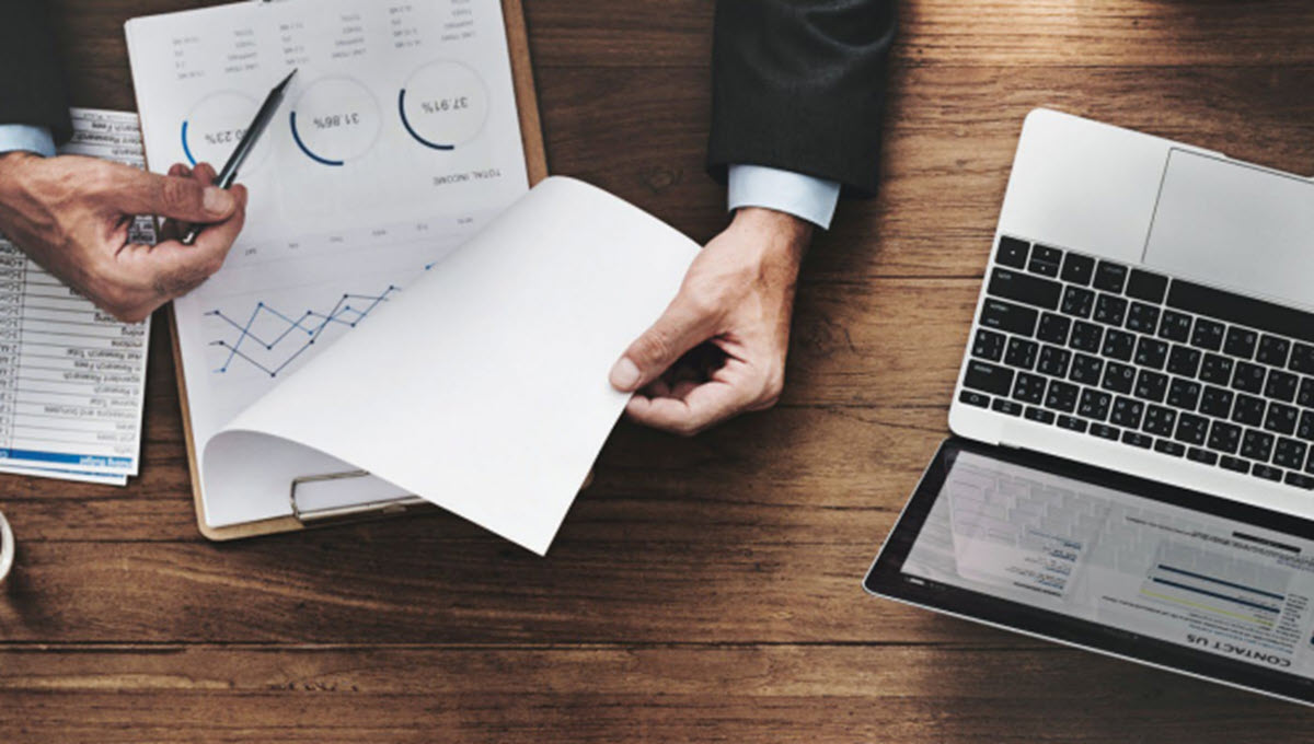 Computer and clipboard with a chart on a desk