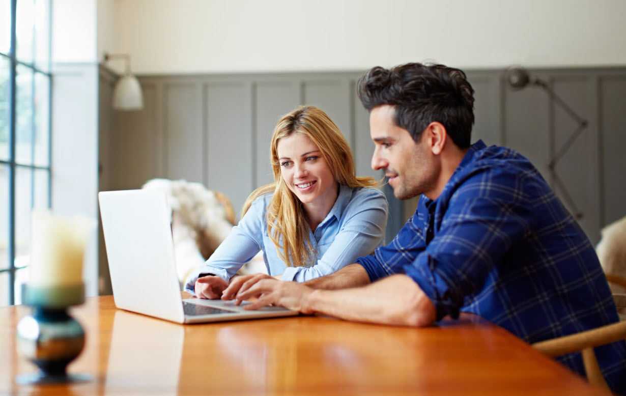 Smiling couple reviewing finances at home