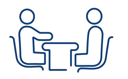 two people sitting at desk icon