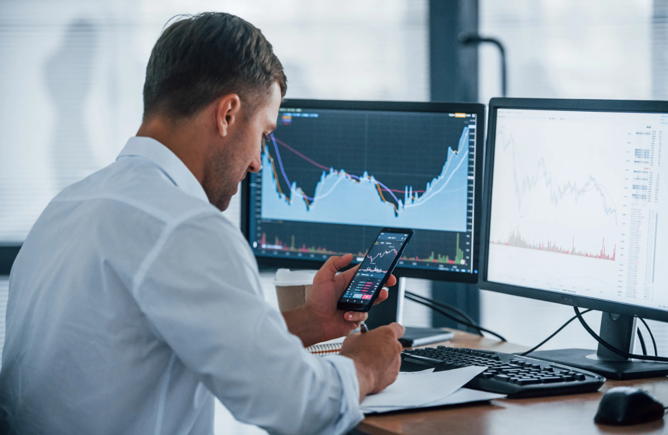 Business man looking at multiple screens